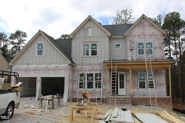 property in mid-construction featuring covered porch, roof with shingles, board and batten siding, and a garage