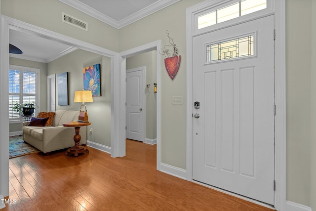 entryway with light hardwood / wood-style flooring and crown molding