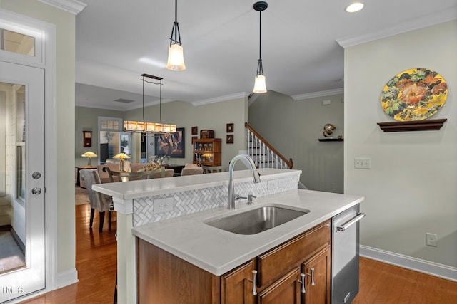 kitchen with pendant lighting, an inviting chandelier, dark hardwood / wood-style flooring, ornamental molding, and sink