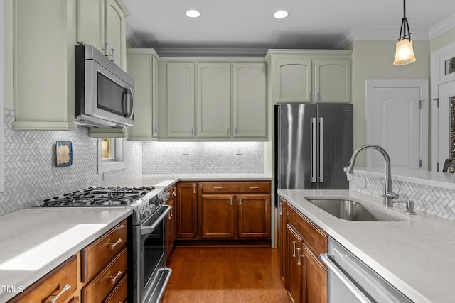 kitchen featuring decorative light fixtures, tasteful backsplash, appliances with stainless steel finishes, ornamental molding, and sink