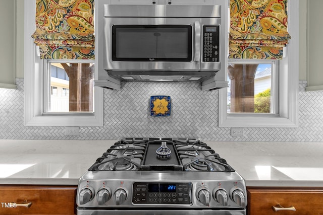 kitchen with light stone countertops and appliances with stainless steel finishes