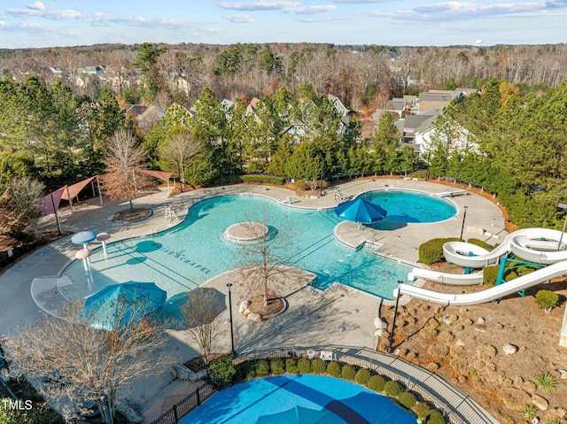 view of swimming pool featuring a patio, a diving board, and a water slide