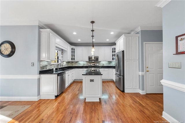 kitchen with white cabinets, a center island, stainless steel appliances, and hanging light fixtures