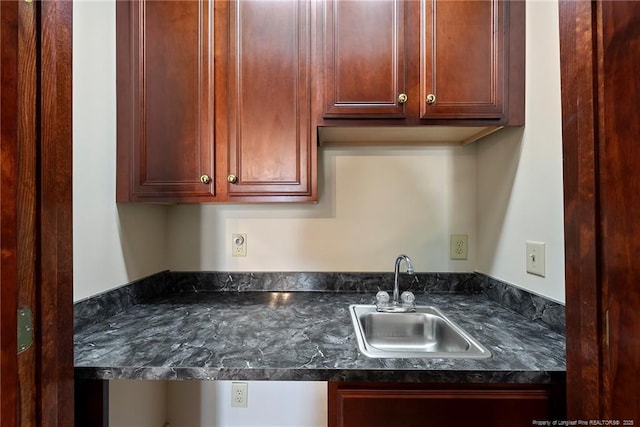 kitchen featuring dark stone countertops and sink