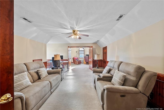 living room featuring ceiling fan, a textured ceiling, and vaulted ceiling