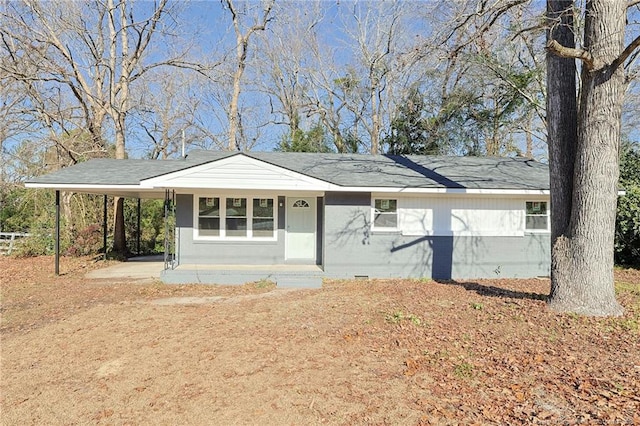 ranch-style home featuring a carport and covered porch