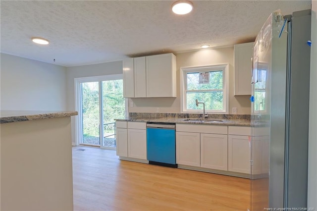 kitchen featuring white cabinets, a textured ceiling, and appliances with stainless steel finishes