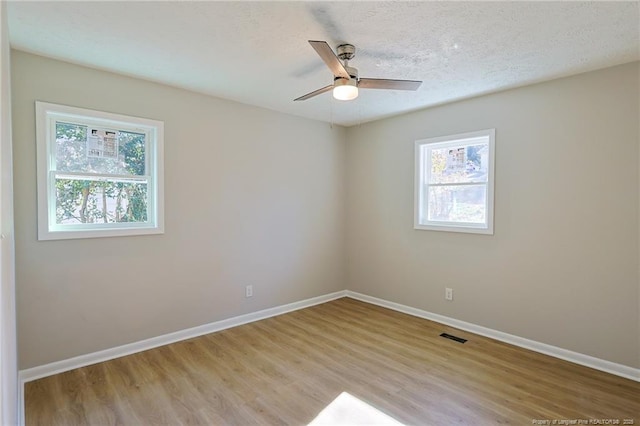 empty room featuring ceiling fan, a textured ceiling, and light wood-type flooring