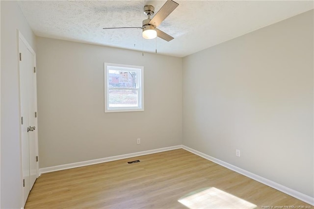 spare room with a textured ceiling, light hardwood / wood-style flooring, and ceiling fan