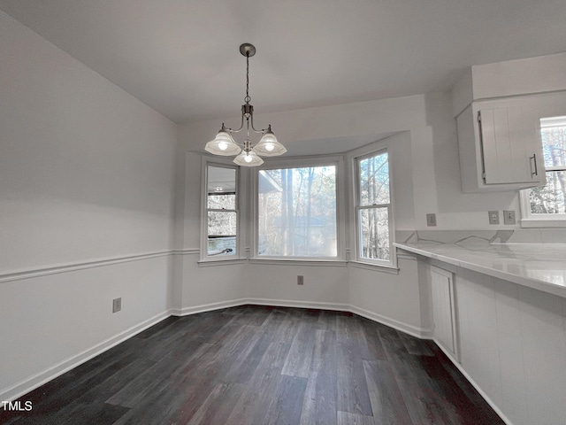 unfurnished dining area with dark hardwood / wood-style floors and a notable chandelier