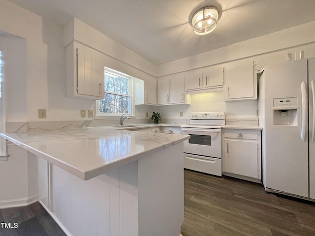 kitchen with sink, white appliances, white cabinetry, dark hardwood / wood-style flooring, and kitchen peninsula