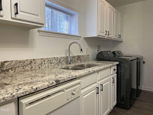 laundry room featuring dark hardwood / wood-style floors, cabinets, sink, and washing machine and dryer