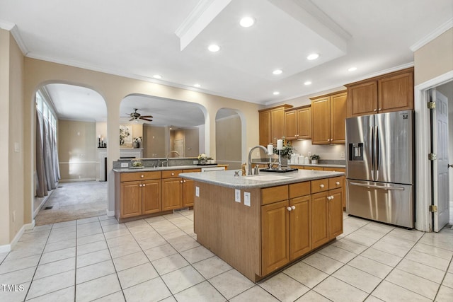 kitchen featuring sink, a center island with sink, ceiling fan, and stainless steel fridge with ice dispenser