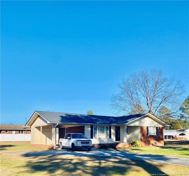 ranch-style home featuring a carport and a front yard