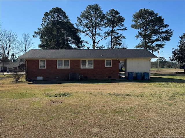 rear view of property with central air condition unit and a lawn