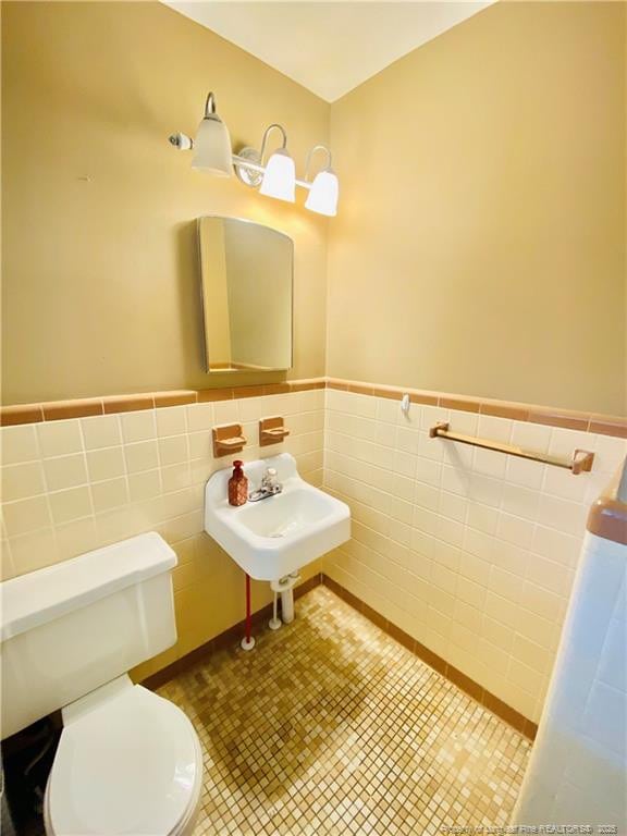 bathroom with sink, tile walls, tile patterned floors, and toilet