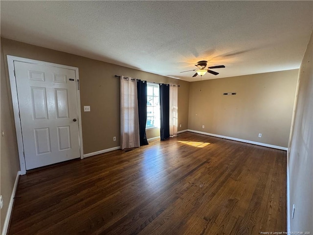 spare room featuring ceiling fan, dark wood-type flooring, and a textured ceiling