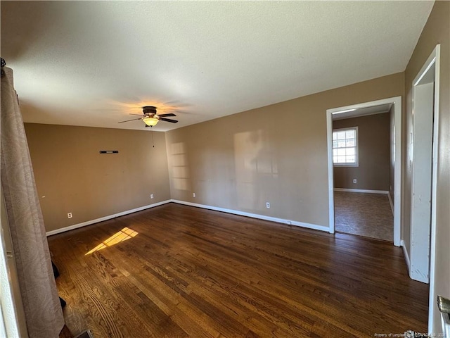 spare room with dark wood-type flooring, ceiling fan, and a textured ceiling