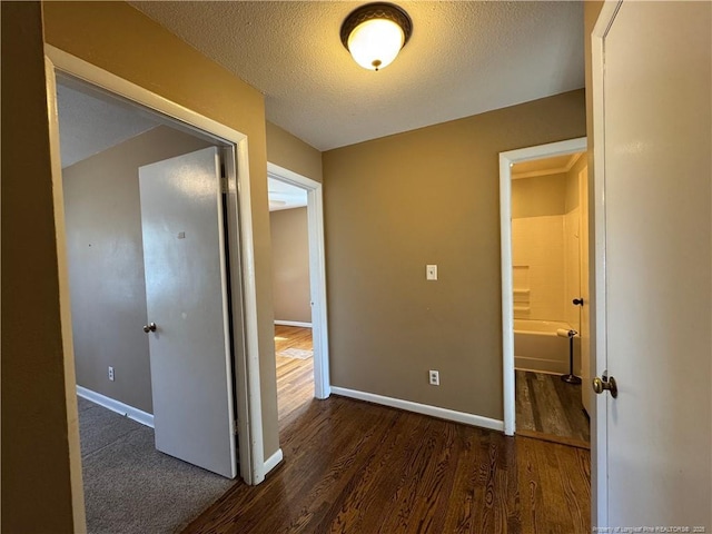 hall with dark hardwood / wood-style flooring and a textured ceiling