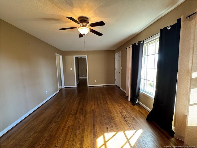 unfurnished bedroom with dark wood-type flooring, ceiling fan, and a textured ceiling