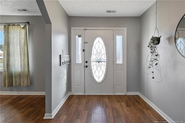 entryway with a textured ceiling and dark hardwood / wood-style floors