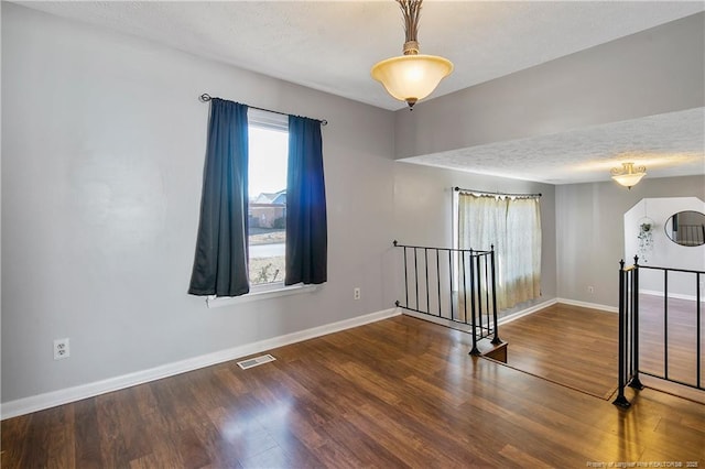 spare room with a textured ceiling and hardwood / wood-style flooring