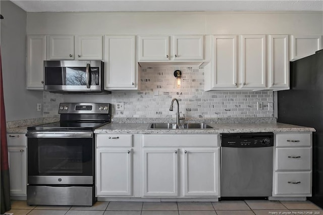 kitchen featuring sink, white cabinets, stainless steel appliances, and light tile patterned floors