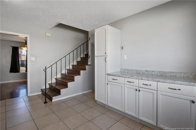 staircase featuring tile patterned floors and a textured ceiling