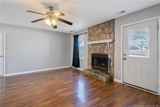 unfurnished living room with a fireplace, ceiling fan, and dark wood-type flooring