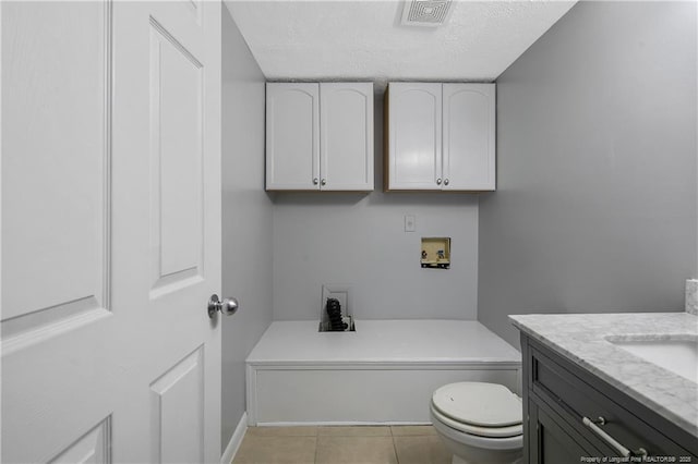 bathroom featuring toilet, vanity, and tile patterned floors