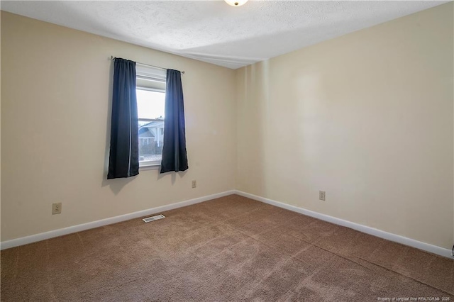 empty room with carpet flooring and a textured ceiling