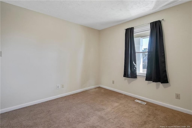 carpeted spare room featuring a textured ceiling