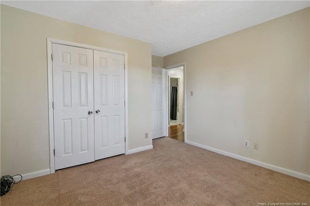 unfurnished bedroom featuring light colored carpet and a closet