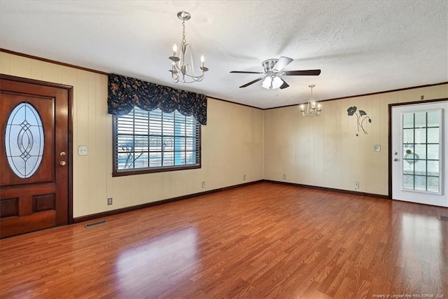 foyer with hardwood / wood-style floors, ceiling fan with notable chandelier, crown molding, and a textured ceiling