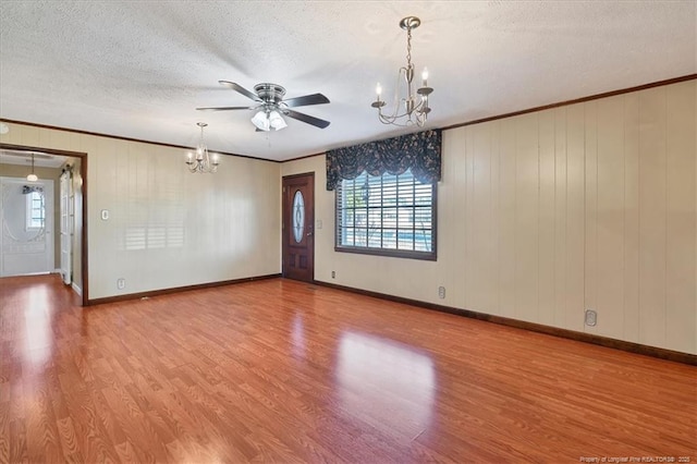 unfurnished room featuring hardwood / wood-style floors, ceiling fan with notable chandelier, a textured ceiling, and crown molding