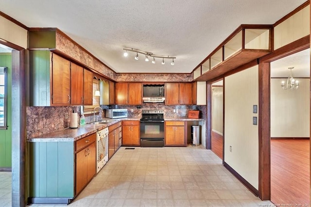 kitchen featuring sink, dishwasher, hanging light fixtures, black range with electric cooktop, and a chandelier