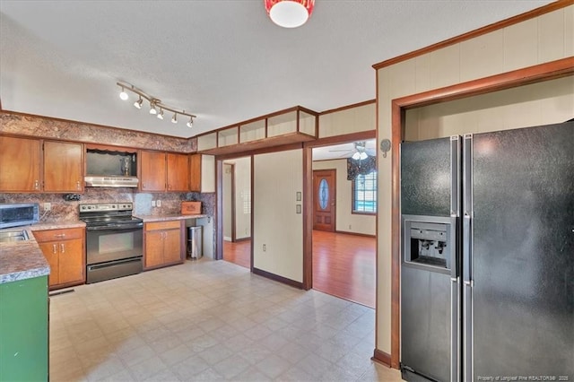 kitchen featuring black fridge, ventilation hood, ceiling fan, sink, and electric stove