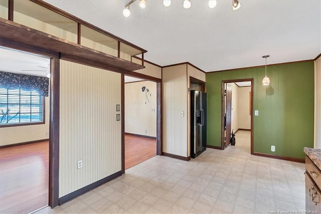 empty room featuring ceiling fan and crown molding