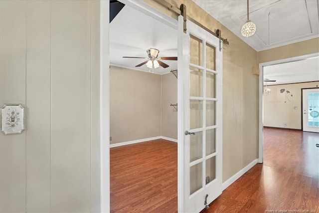 hall featuring a barn door and wood-type flooring