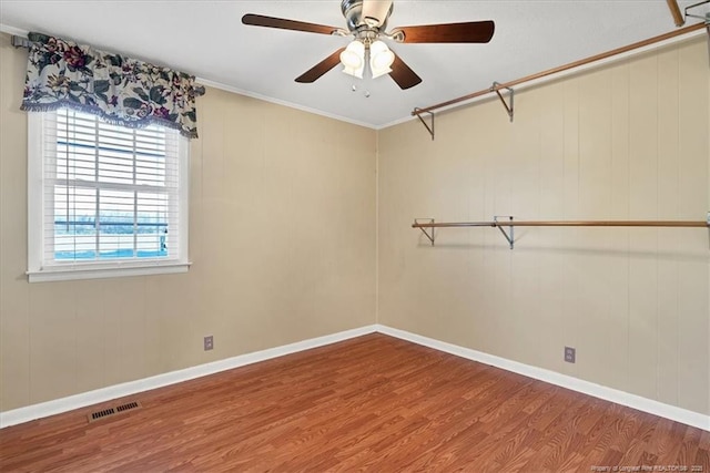 empty room with hardwood / wood-style flooring, ceiling fan, and crown molding