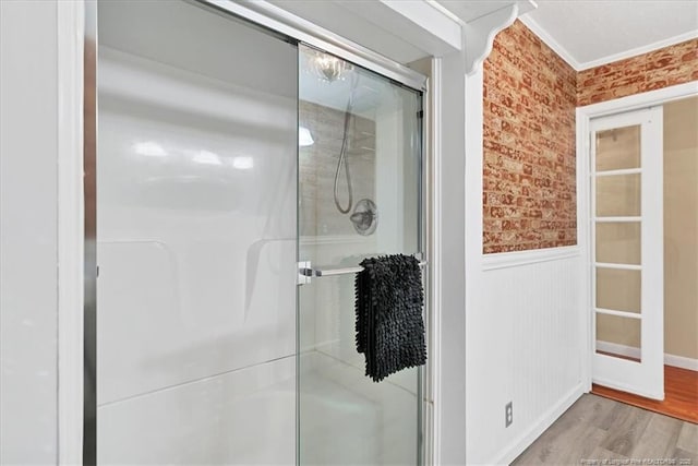 bathroom featuring crown molding, hardwood / wood-style floors, and an enclosed shower