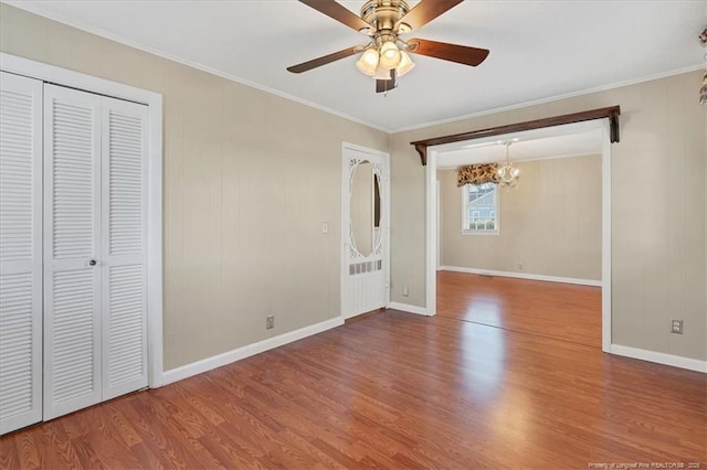 unfurnished bedroom featuring ceiling fan with notable chandelier, hardwood / wood-style flooring, a closet, and ornamental molding