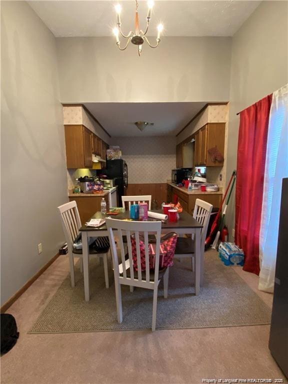 dining room with light carpet and a chandelier