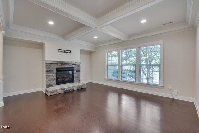 unfurnished living room featuring beam ceiling, coffered ceiling, a stone fireplace, dark hardwood / wood-style floors, and crown molding