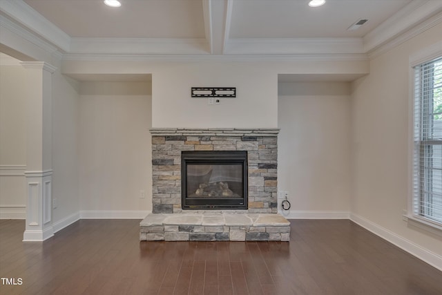 unfurnished living room featuring beamed ceiling, dark hardwood / wood-style flooring, a stone fireplace, and crown molding