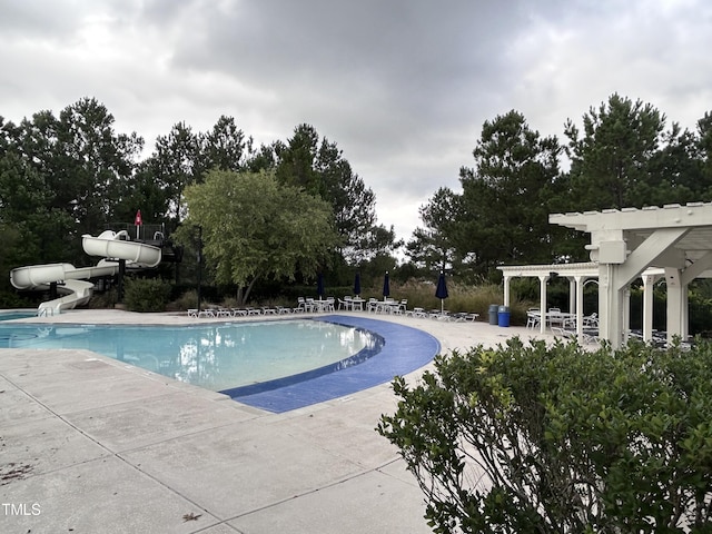 view of swimming pool with a pergola, a patio, and a water slide