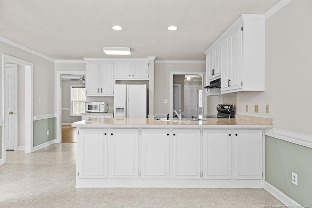 kitchen featuring kitchen peninsula, white appliances, white cabinetry, and sink