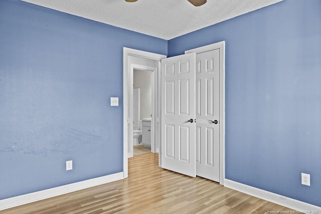 unfurnished bedroom with ceiling fan, light hardwood / wood-style floors, and a textured ceiling