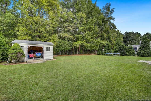 view of yard featuring an outdoor structure and a trampoline