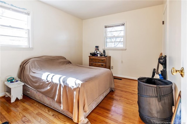 bedroom with multiple windows and light hardwood / wood-style floors